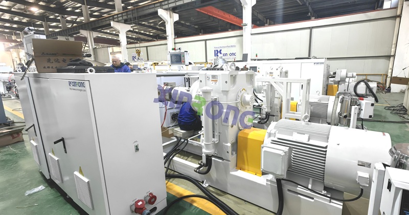 Industrial PE pipe extrusion machine by XinRong in factory with workers operating equipment - HDPE pipe production line setup.jpg Industrial PE pipe extrusion machine by XinRong in factory with workers operating equipment - HDPE pipe production line setup.jpg