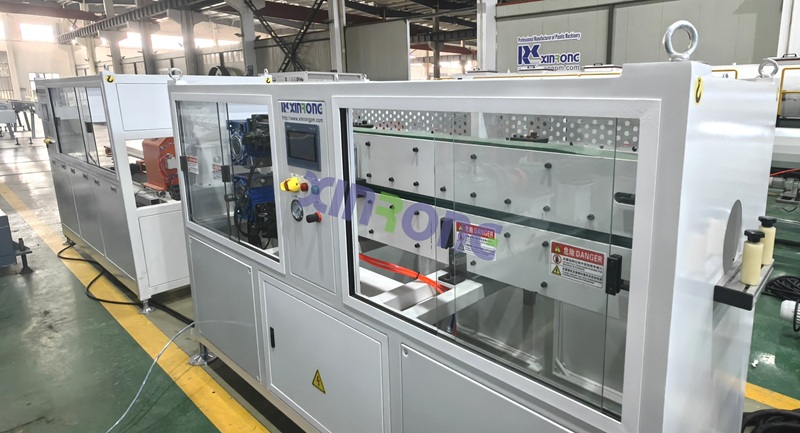 White PE pipe production machine with glass window and control panel - Xinrong brand with danger safety warning label.jpg